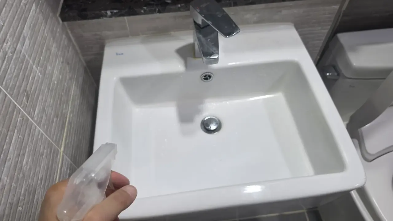 A cleaned bathroom basin with water beading on the surface