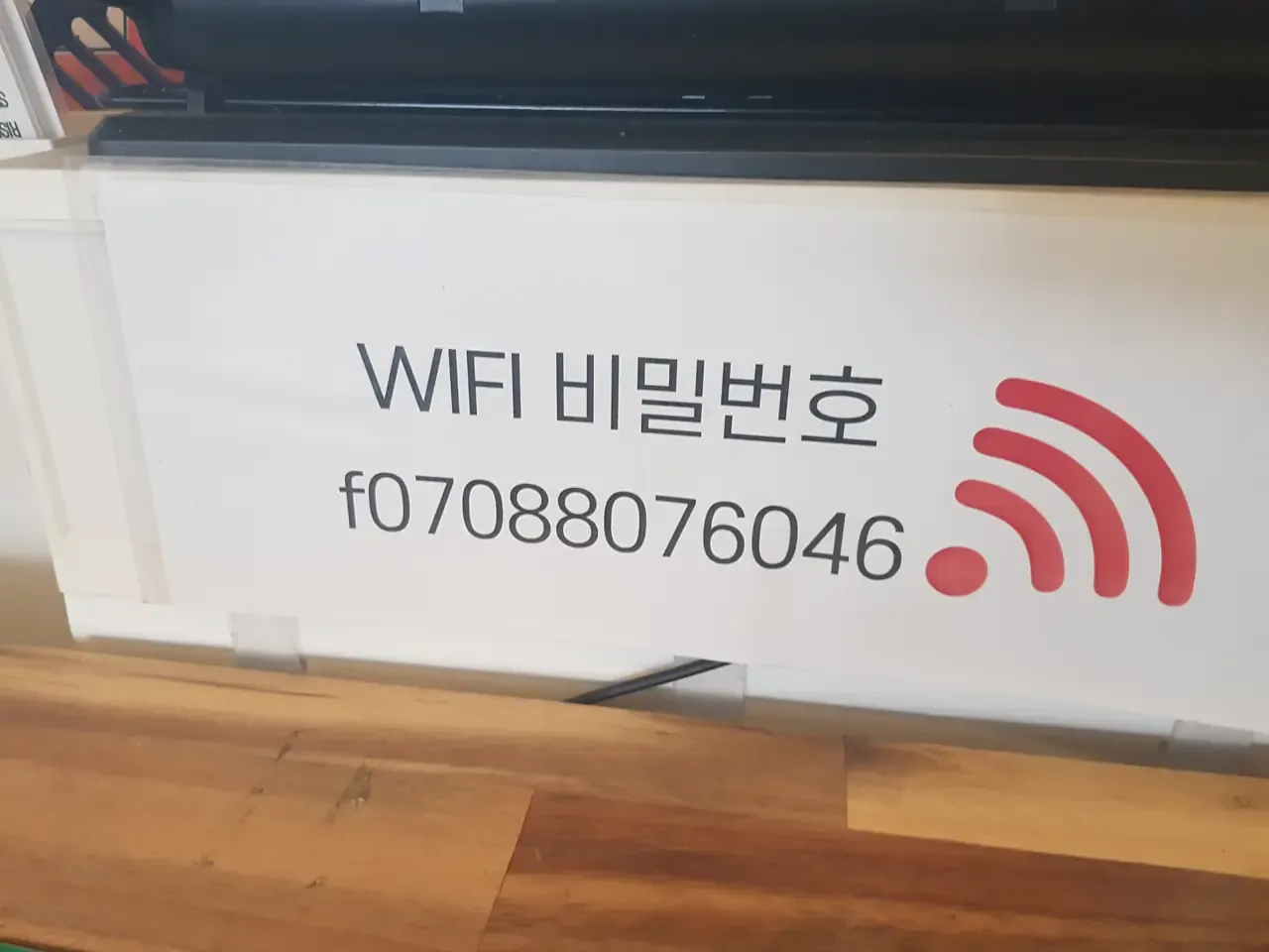 A cafe counter sign giving the Wi-Fi password