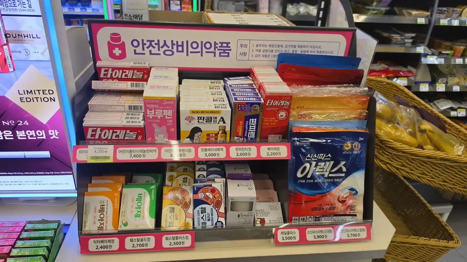 A convenience store display stand labelled 안전상비의약품 with Tylenol, children's Tylenol suspension, Brufen syrup, Pancol A, Panpyrin, Bearse digestive tablets and pain patches, each with a price tag