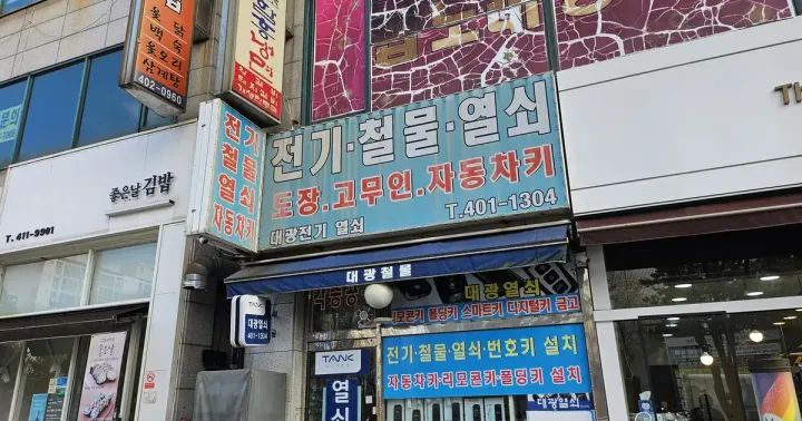 A Seoul shopfront sign reading 전기 철물 열쇠 — electrical, hardware and keys — above a small neighbourhood shop