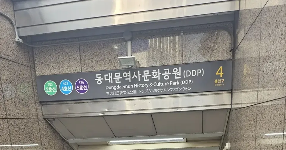 A Seoul subway entrance sign for Dongdaemun History & Culture Park (DDP) showing three line badges — green 205, blue 422, purple 536