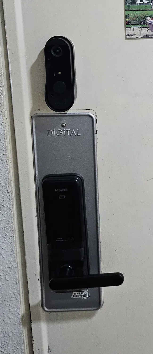 Close-up of the outside panel of a Korean digital door lock with the maker's name MILRE moulded into the plastic
