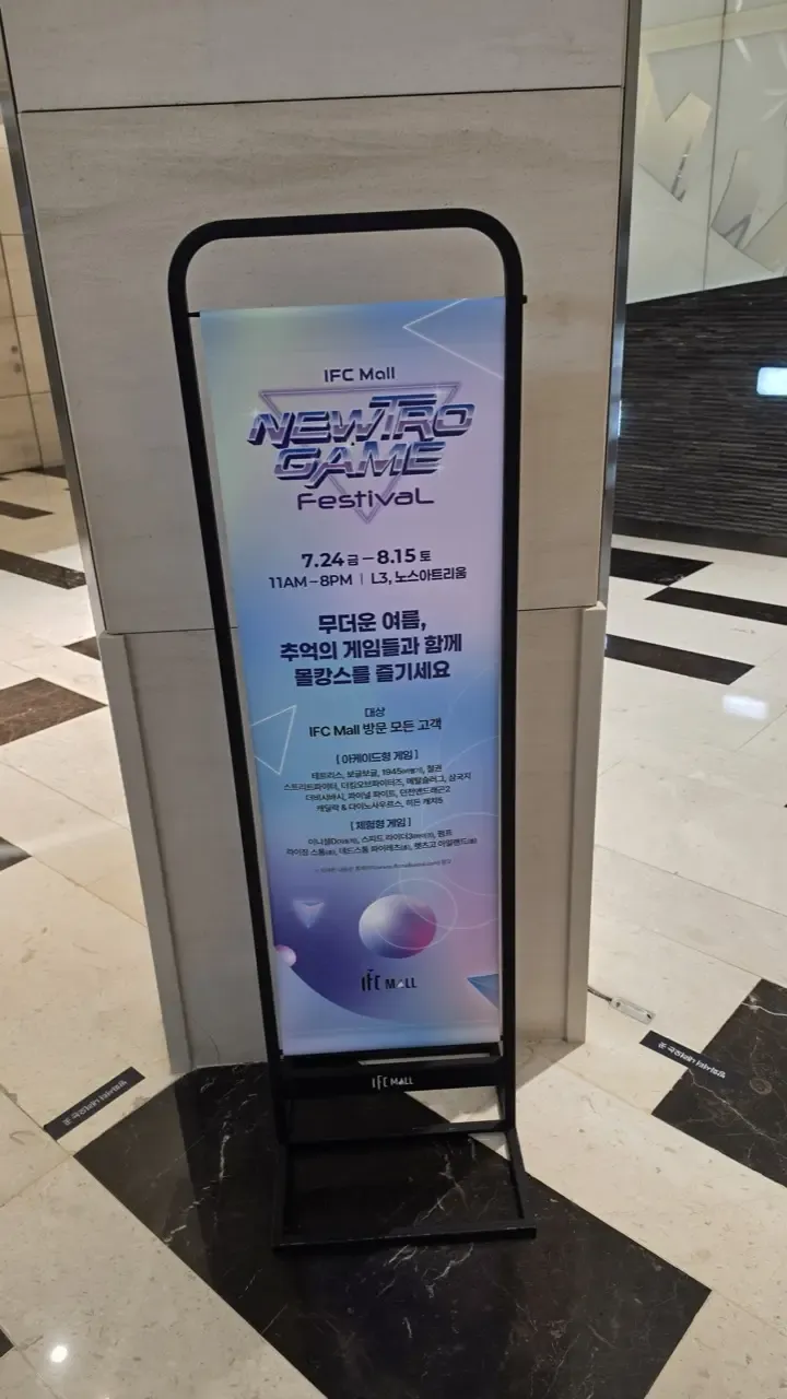 Standing banner for the IFC Mall Newtro Game Festival showing dates and game list
