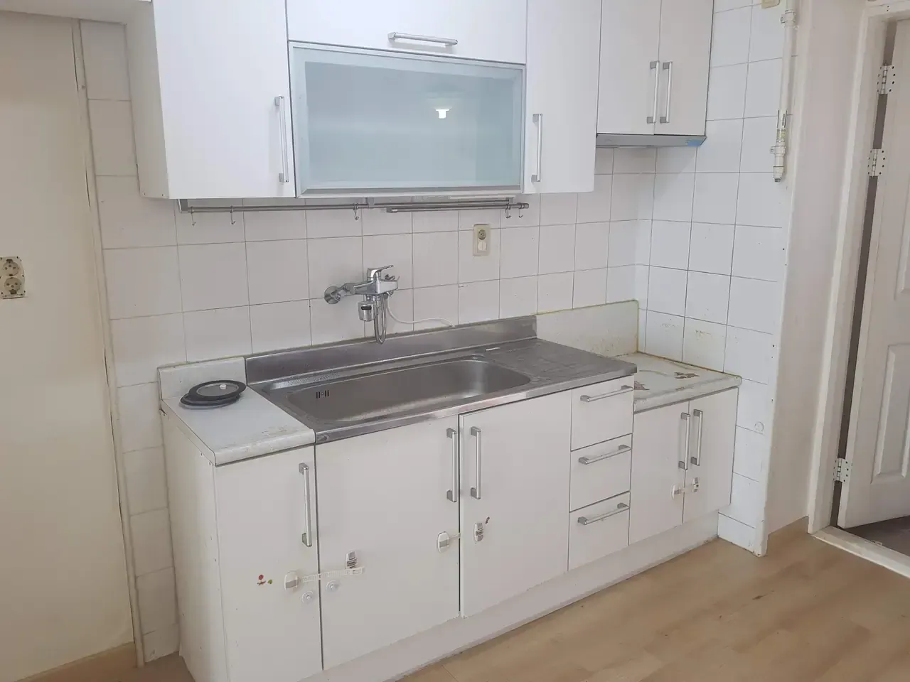 A kitchen worktop in an empty flat, stained and marked along the edge
