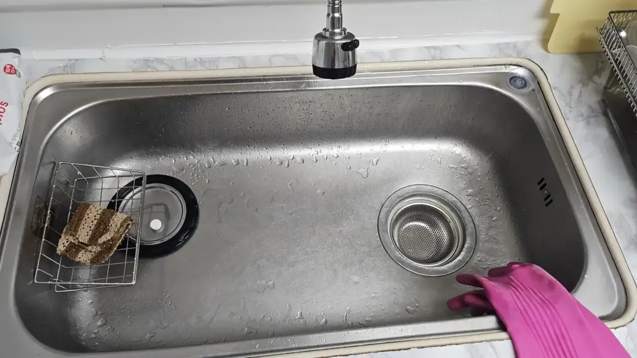 The same stainless kitchen sink after cleaning, empty and polished