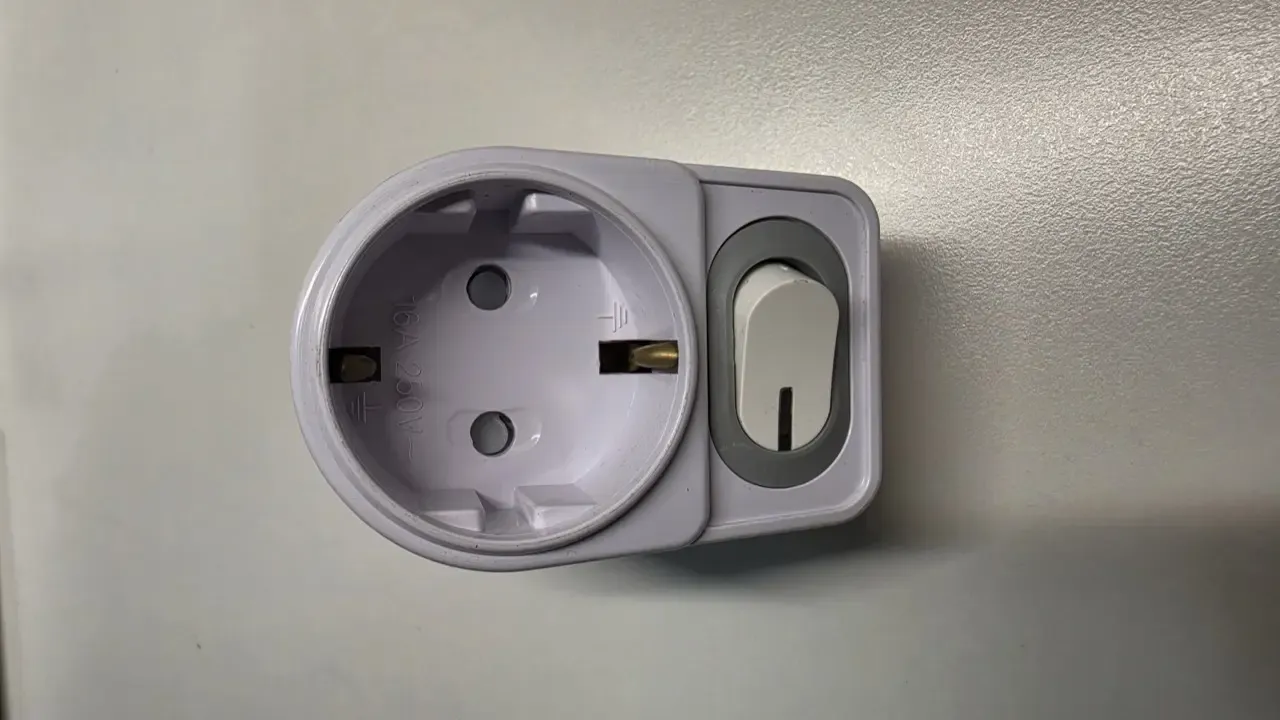 A round recessed Korean wall outlet next to a light switch, marked 16A 250V