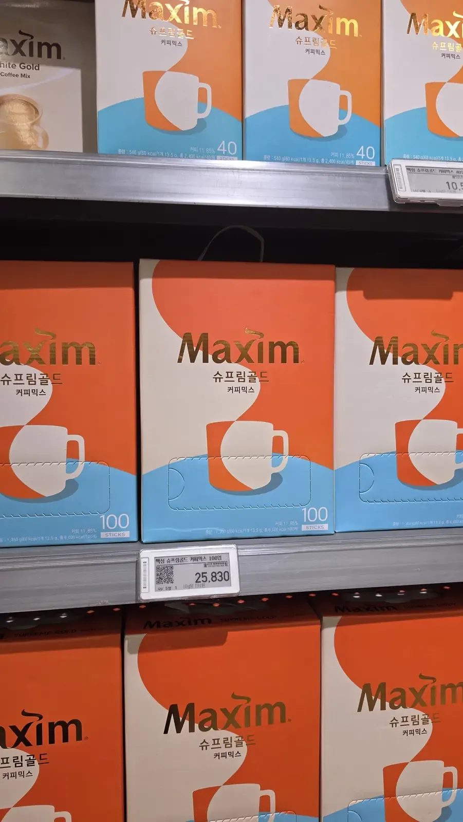 Orange boxes of Maxim Supreme Gold coffee mix, 100 sticks, priced at 25,830 won