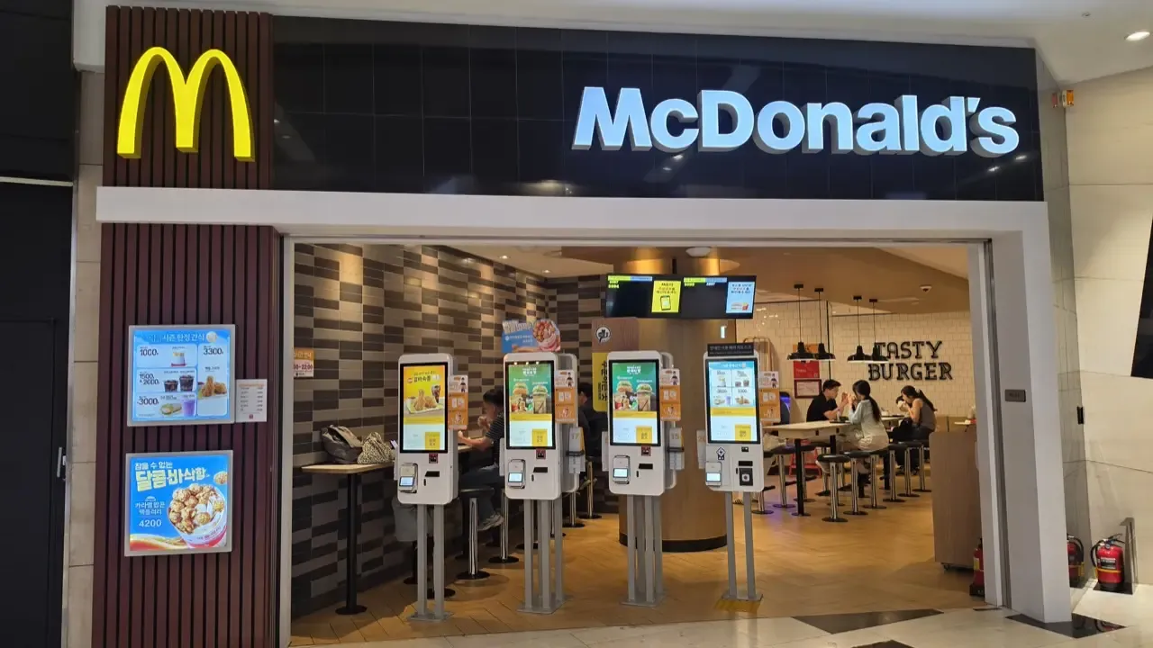 A row of four self-order kiosks at the entrance of a McDonald's in Seoul