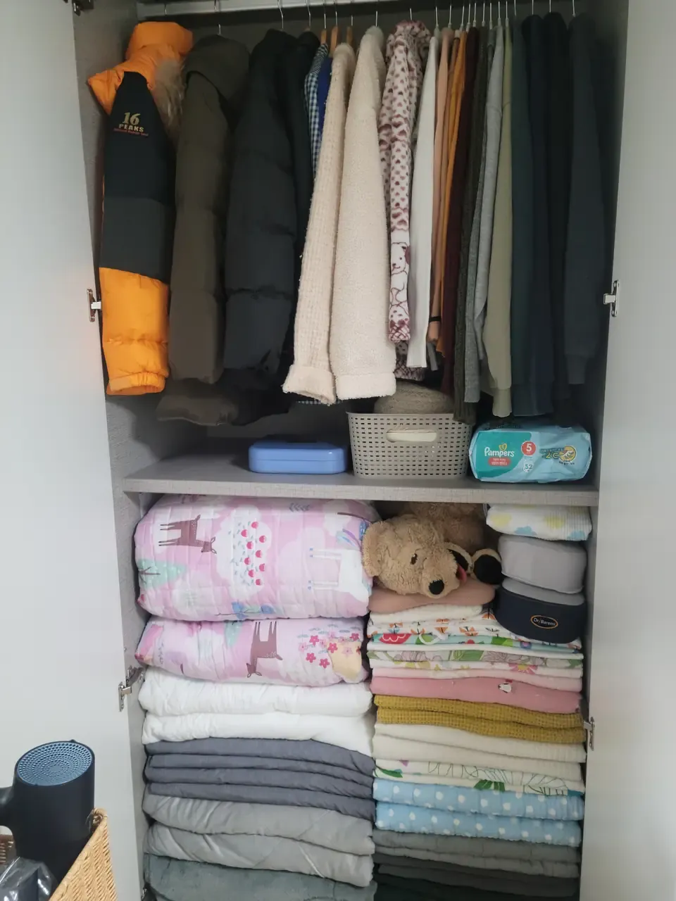 A Korean wardrobe after a housekeeping visit — duvets, blankets and winter jackets folded and stacked in order