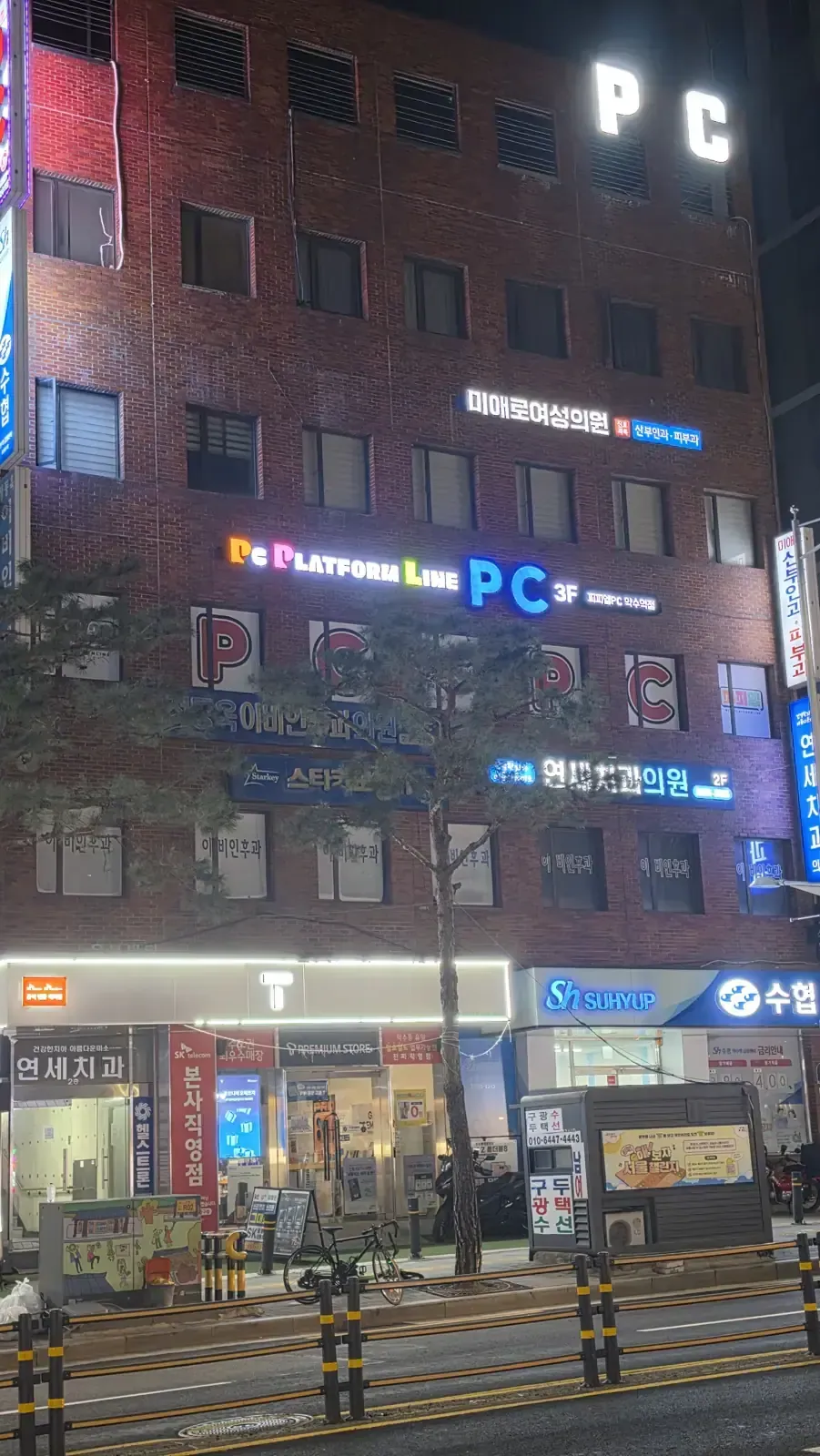 A Seoul building at night with PC signs lit on several floors