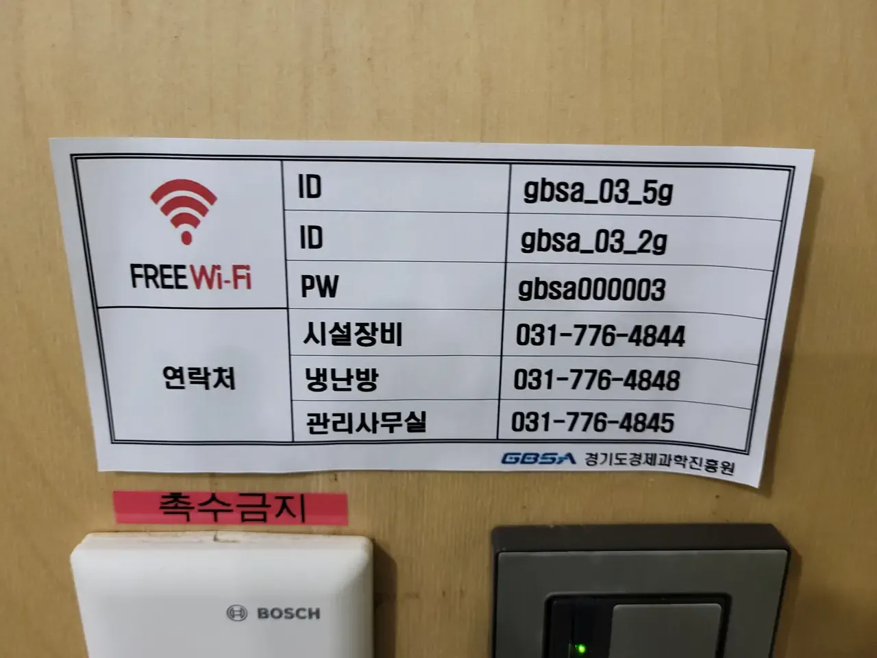 A printed notice in a public building listing the free Wi-Fi network name and password