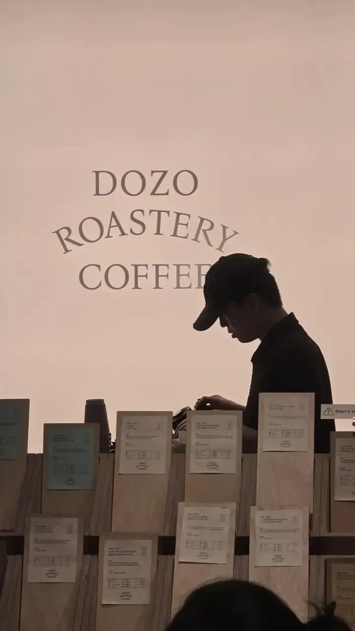 A wall of coffee bean bags at a Korean roastery, each with a printed card listing origin, process and tasting notes