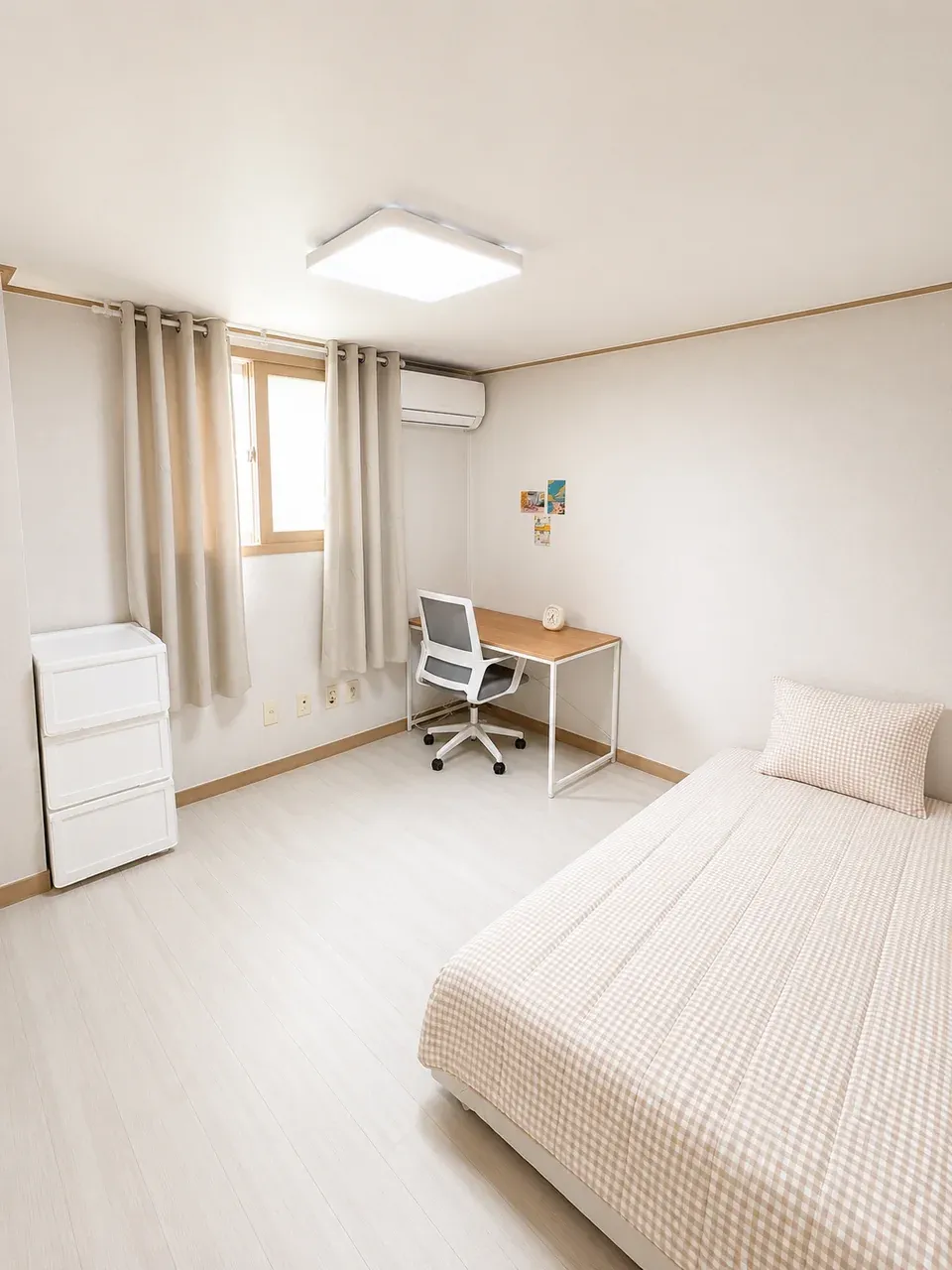 The same room type turned around: the bed runs along the right-hand wall and the desk sits in the far corner beneath the air conditioner