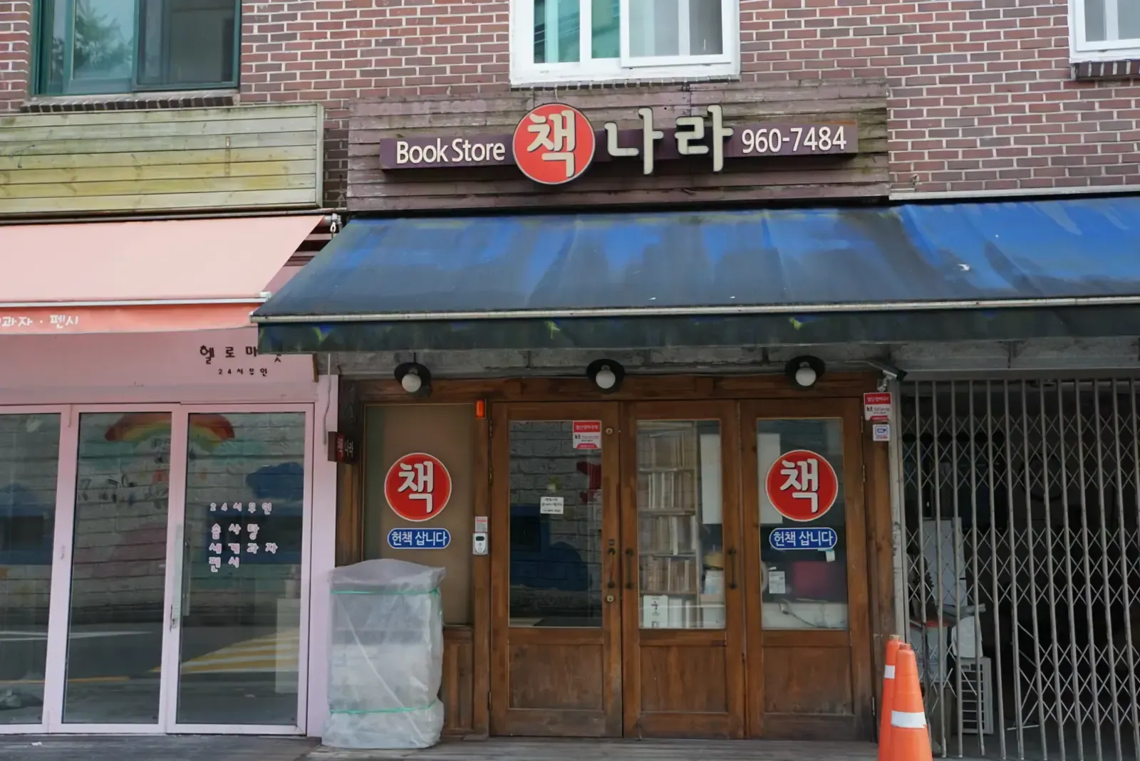 The storefront of an old secondhand bookstore in Seoul with a red and white sign reading Book Store 책나라