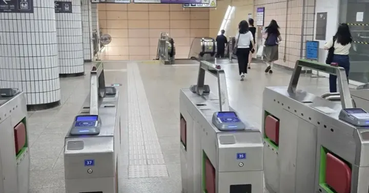 Fare gates in a Seoul subway station beneath a sign reading 타는 곳 Tracks