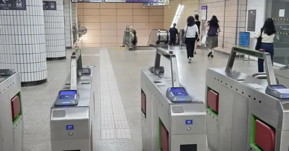 Fare gates in a Seoul subway station beneath a sign reading 타는 곳 Tracks
