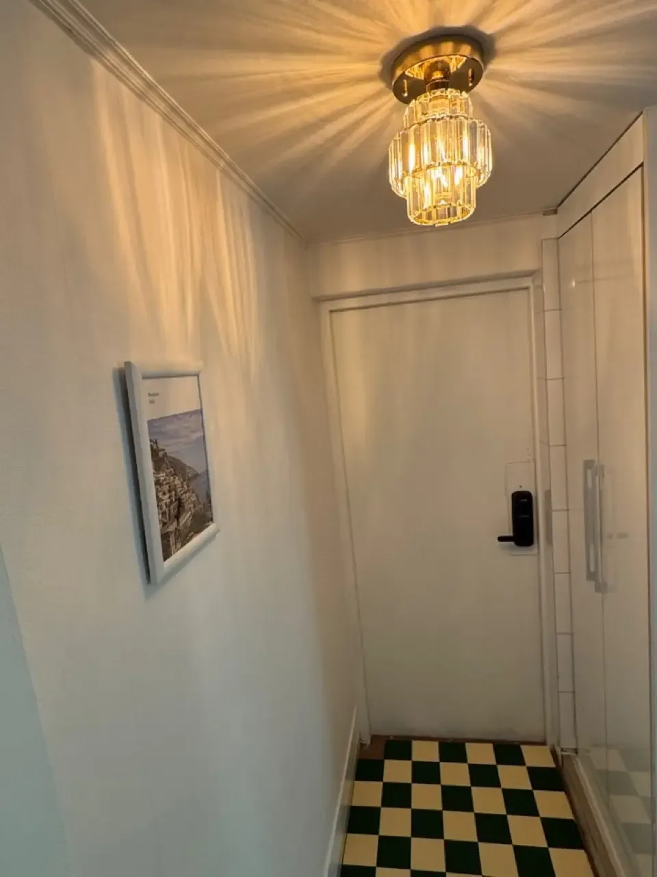 The entrance hallway of a Seoul share house with a keypad door lock