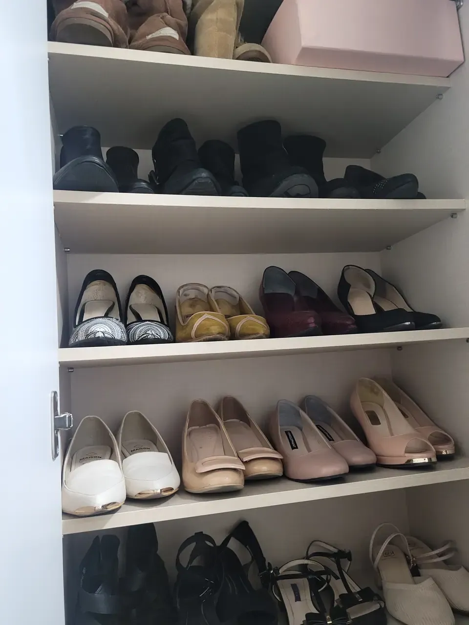 A shoe cabinet after organising, with pairs arranged by type in vertical columns