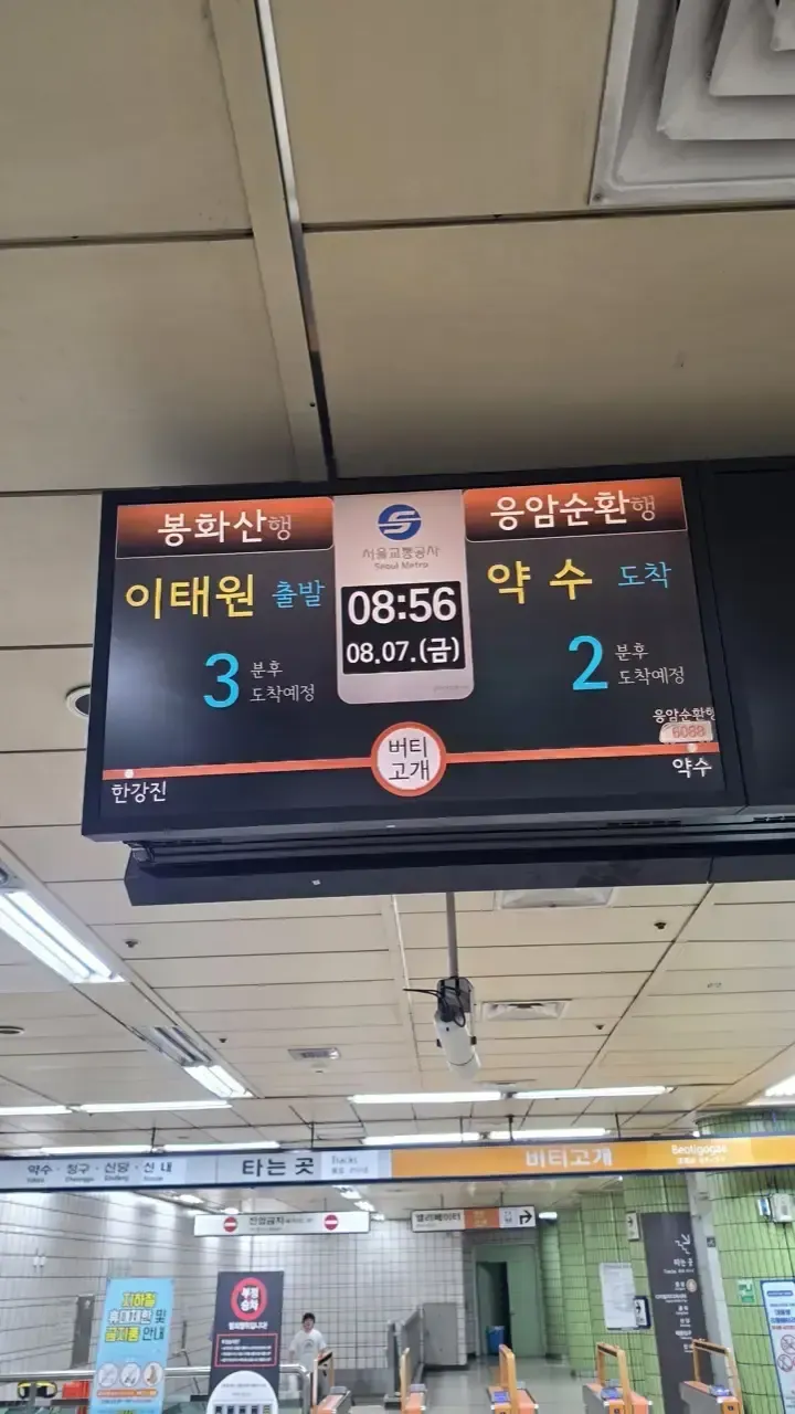 An arrival board on a Seoul subway platform showing trains 3 minutes and 2 minutes away