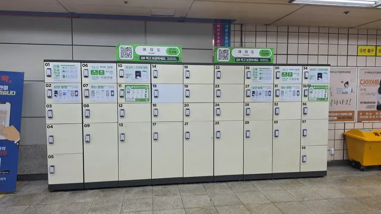 A wall of coin lockers in a Seoul subway station with QR code instructions
