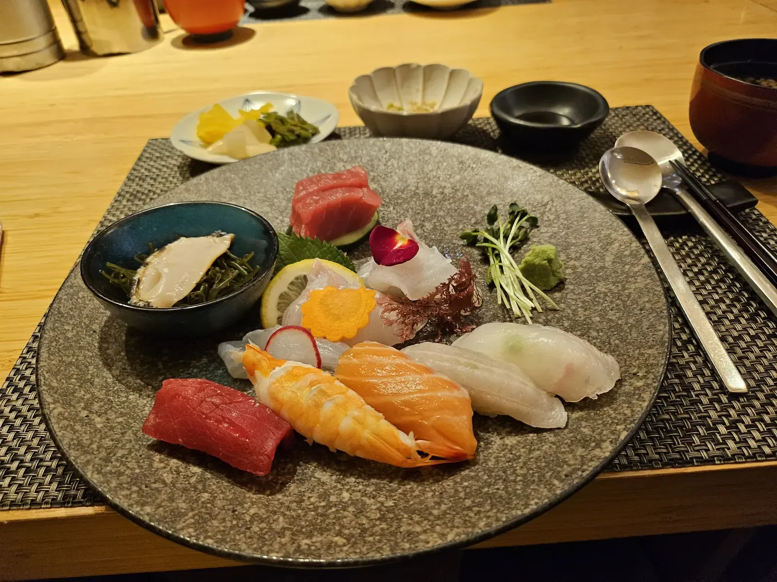 A plate of assorted nigiri and sashimi with wasabi and pickles at a Japanese restaurant in Seoul