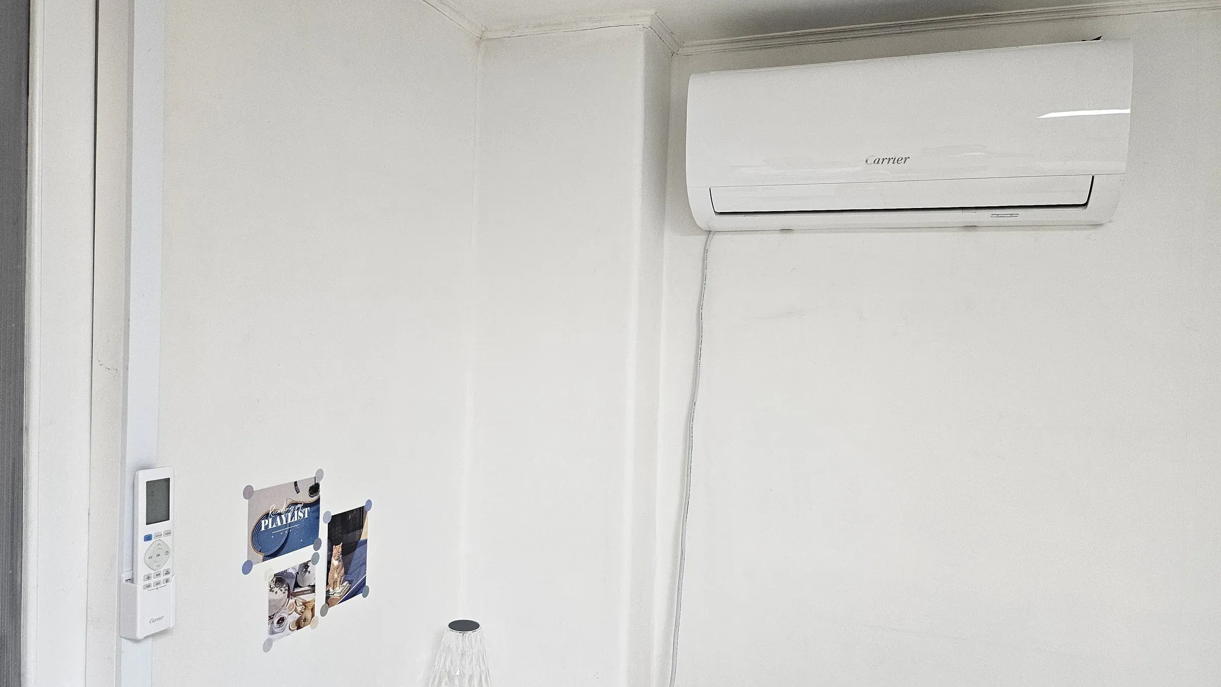 A wall air conditioner and its remote in a wall holder, the front panel closed